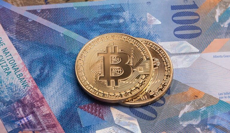 Notas de dinheiro com duas moedas de bitcoin em cima.