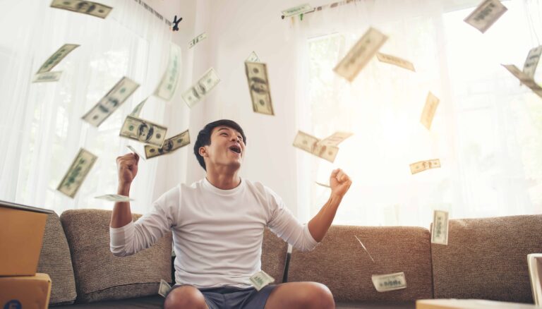 happy man with cash dollars flying in home office rich from business online concept scaled