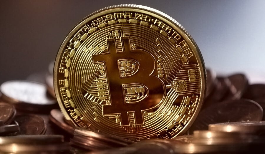 Moeda de bitcoin em cima de moedas convencionais.