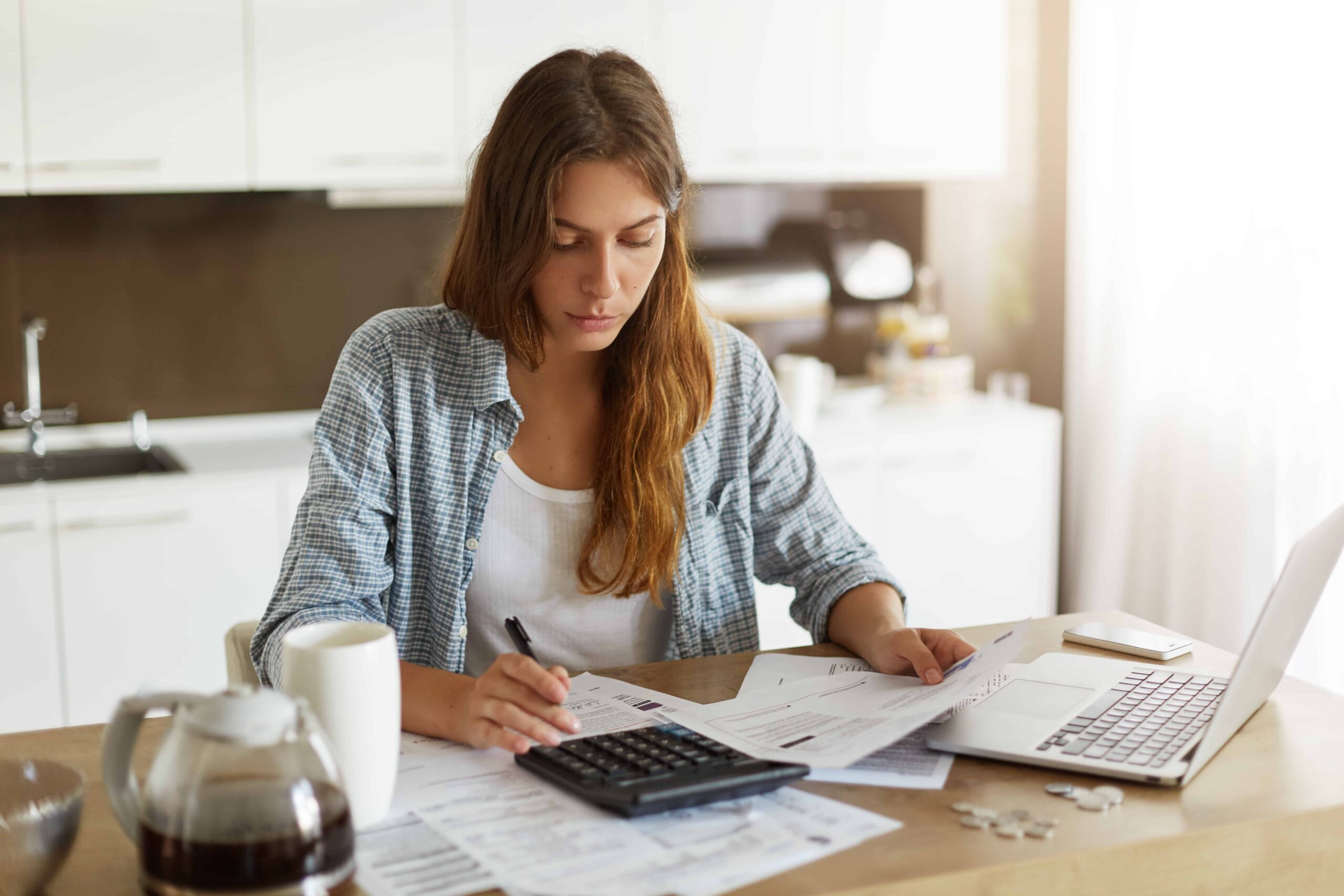 young woman checking her budget and doing taxes scaled